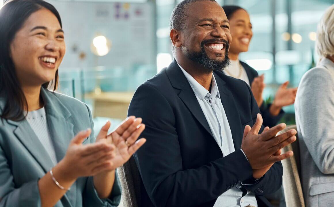 Un groupe d'employés divers sourit et applaudit