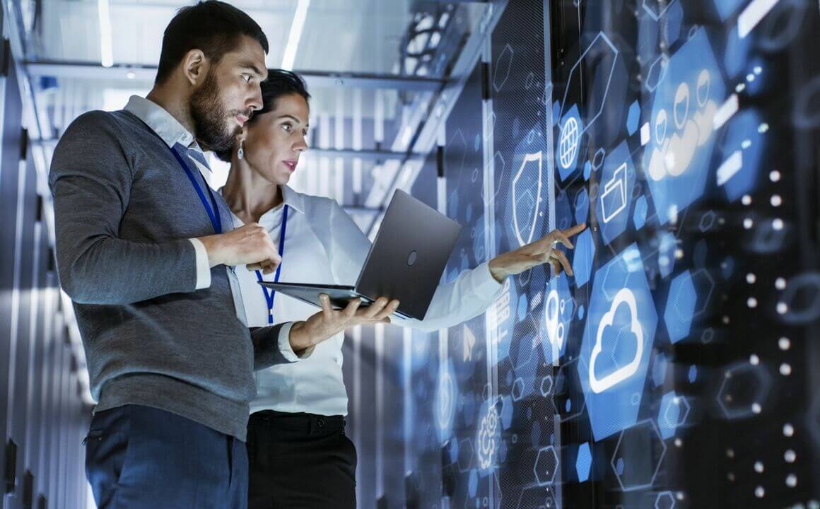 Two employees working in a data center server room.