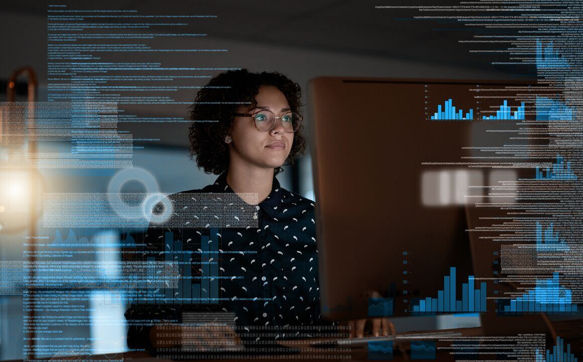 A woman analyzing data on a large computer monitor